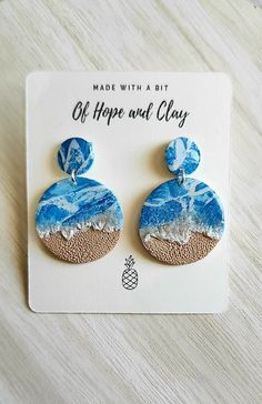 a pair of blue and white earrings sitting on top of a card