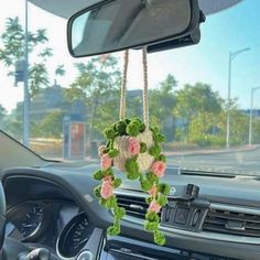 a car dashboard with flowers hanging from it's dash board in the front seat