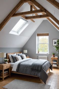 a bed sitting under a window in a bedroom next to a wooden table and chair