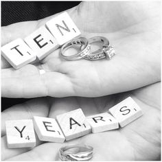 two hands holding letters that spell out the word ten years with wedding rings on them