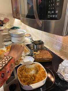 people are preparing food in the kitchen on the stove top, and one person is reaching for something