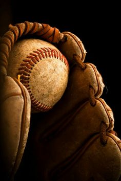 an old baseball glove with a ball in it