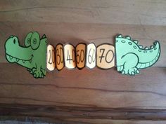 the word alligator spelled out with cut outs in front of them on a wooden surface