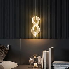 a lamp hanging over a bed next to a book shelf with books on top of it