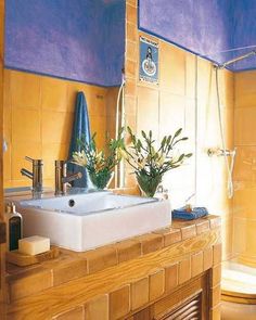 a bathroom with yellow tiles and blue accents