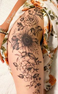 a woman's thigh with sunflowers and roses on it