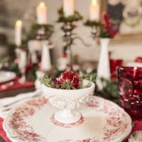 a red and white christmas table setting with candles