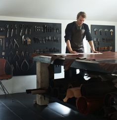 a man standing at a table with lots of tools on it