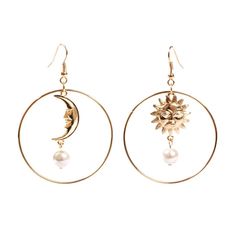 a pair of earrings with the moon and sun on it, hanging from hoops