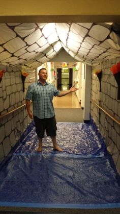 a man is standing in the middle of a room made out of cardboard blocks and duct tape