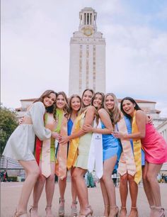 a group of young women standing next to each other in front of a tall building