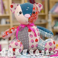 a teddy bear sitting on top of a table next to sewing needles and other crafting supplies