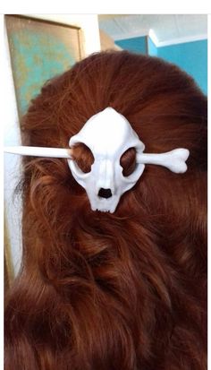 a woman with long red hair and a fake skull on her head is seen in the mirror