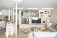 a living room filled with furniture and a flat screen tv sitting on top of a wooden table