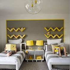 two beds in a bedroom with yellow and gray decor on the headboards, one is made up to look like chevrons