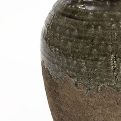 a brown and black vase sitting on top of a table