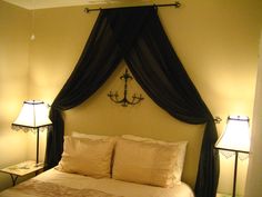 a bed with two lamps on either side and a chandelier hanging above it