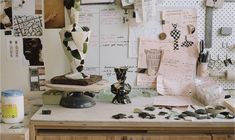 a cluttered desk with sculptures and papers on it