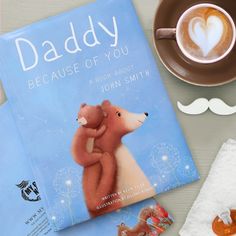 there is a book about daddy and his bear next to a cup of cappuccino