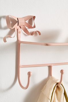 a pink coat rack with two coats hanging on it