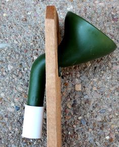 a green and white object on the ground with a wooden stick sticking out of it