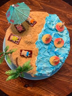 a cake with blue frosting and peaches on it, topped with an umbrella