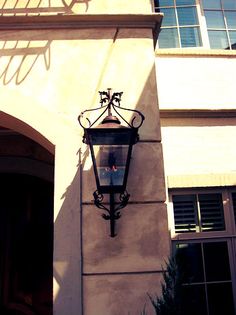 an old fashioned street light on the side of a building