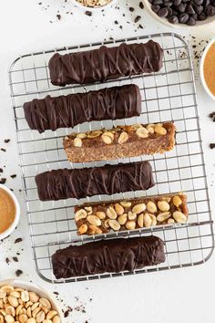 chocolate peanut butter pretzels on a cooling rack with nuts and cocoa in the background