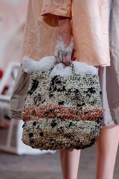 a woman's hand holding a bag with white and black material on the inside