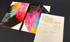 an open brochure with colorful ink splattered on the front and back