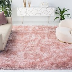 a living room filled with furniture and a pink rug