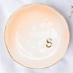 a white and gold plate with the letter s on it