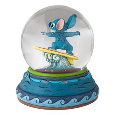 a snow globe with an image of stitchy riding a surfboard in the water