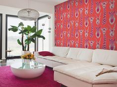 the living room is decorated in pink and white with an orange wallpaper behind it