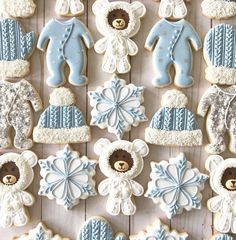 baby shower cookies decorated with blue and white frosting, teddy bears, snowflakes, hats, mittens