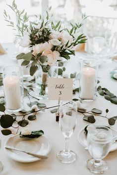 the table is set with candles, plates and napkins for an elegant wedding reception