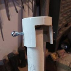 a close up of a door handle on a white pole in a room filled with tools