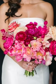 a bride holding a bouquet of pink and red flowers