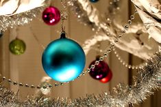 christmas ornaments hanging from a silver tinsel tree