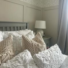 a bed with white sheets and pillows on it