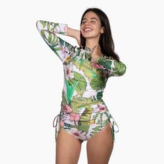 Stylish and protective, the Berry Jane Ruched Side Long Sleeve Swimsuit Rash Guard Set is perfect for active watersports. Fully lined with a built-in bra and removable pads. This beautiful Hawaiian floral print rash guard was made for days spent in the sun and at the beach. UPF 50 protection helps shield your skin from harmful rays, while the ruched sides provide a flattering fit. Whether you're hitting the beach or pool, this rash guard swimsuit is a must-have for your next adventure. Sale item Tropical Stretch Swimwear With Upf 50+, Fitted Summer Rash Guard For Swimming, Summer Rash Guard For Swimming, Fitted Rash Guard For Beach Vacation, Fitted White Rash Guard For Poolside, Fitted Green Rash Guard, Green Rash Guard For Poolside And Beach Season, Green Rash Guard For Swimming, Beach Season, Tropical Fitted Swimwear With Uv Protection