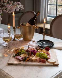 a table with wine, cheese and meats on it