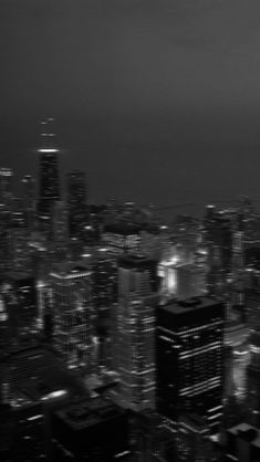 black and white photo of city lights at night from the top of a tall building