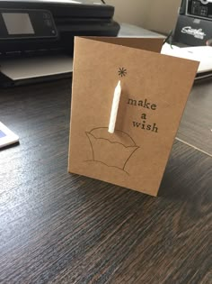 a brown card with a white candle on it sitting on top of a wooden table