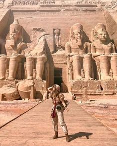 a woman standing in front of an egyptian temple