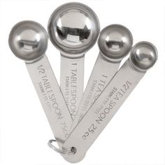 four metal measuring spoons with labels on them