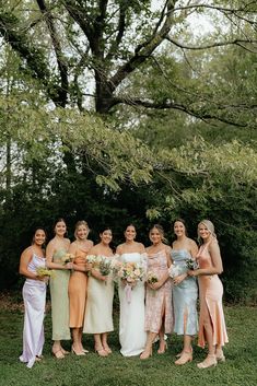 a group of women standing next to each other on top of a lush green field