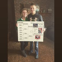 two people standing next to each other holding up a sign