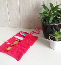 a potted plant sitting next to a pink towel on top of a white table