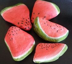 four pieces of watermelon sitting on top of a black surface